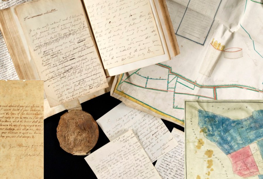 Colour photo showing items from the Archive collections include a volume, document with wax seal and a map
