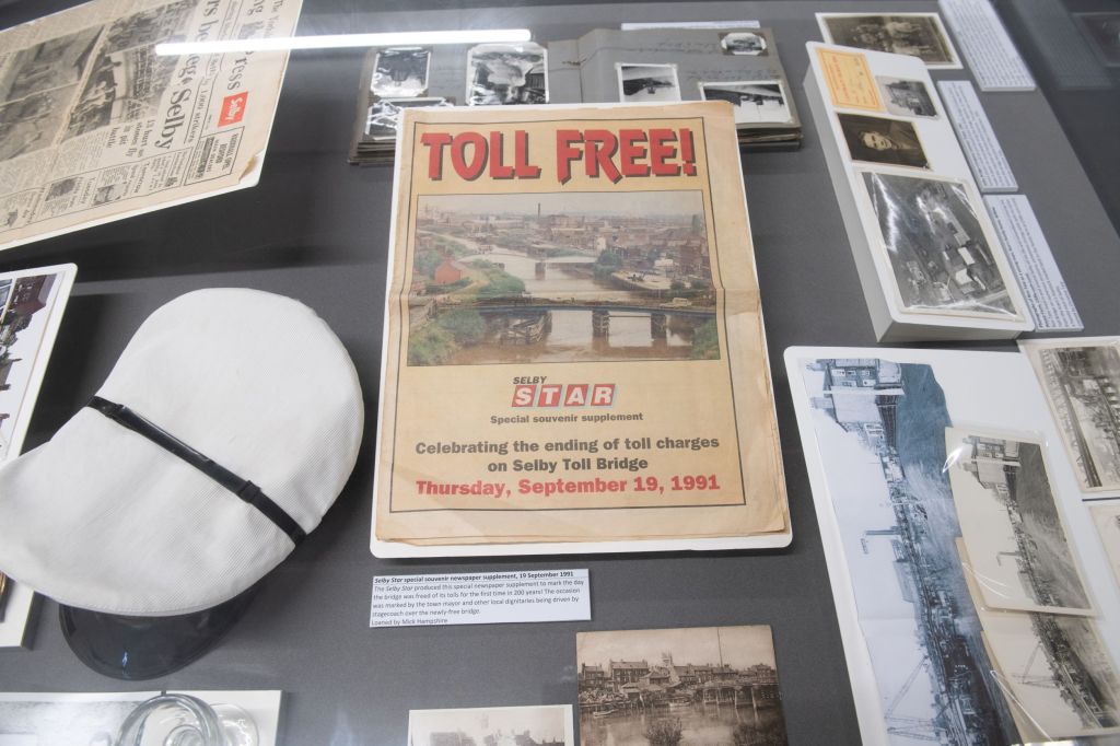 Items in a display case that have been loaned by local people including a supplement from the Selby Star celebrating the ending of toll charges on Selby Toll Bridge 1991, a Toll Collectors cap, photos and postcards. 